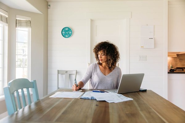 A woman doing paperwork at a table.